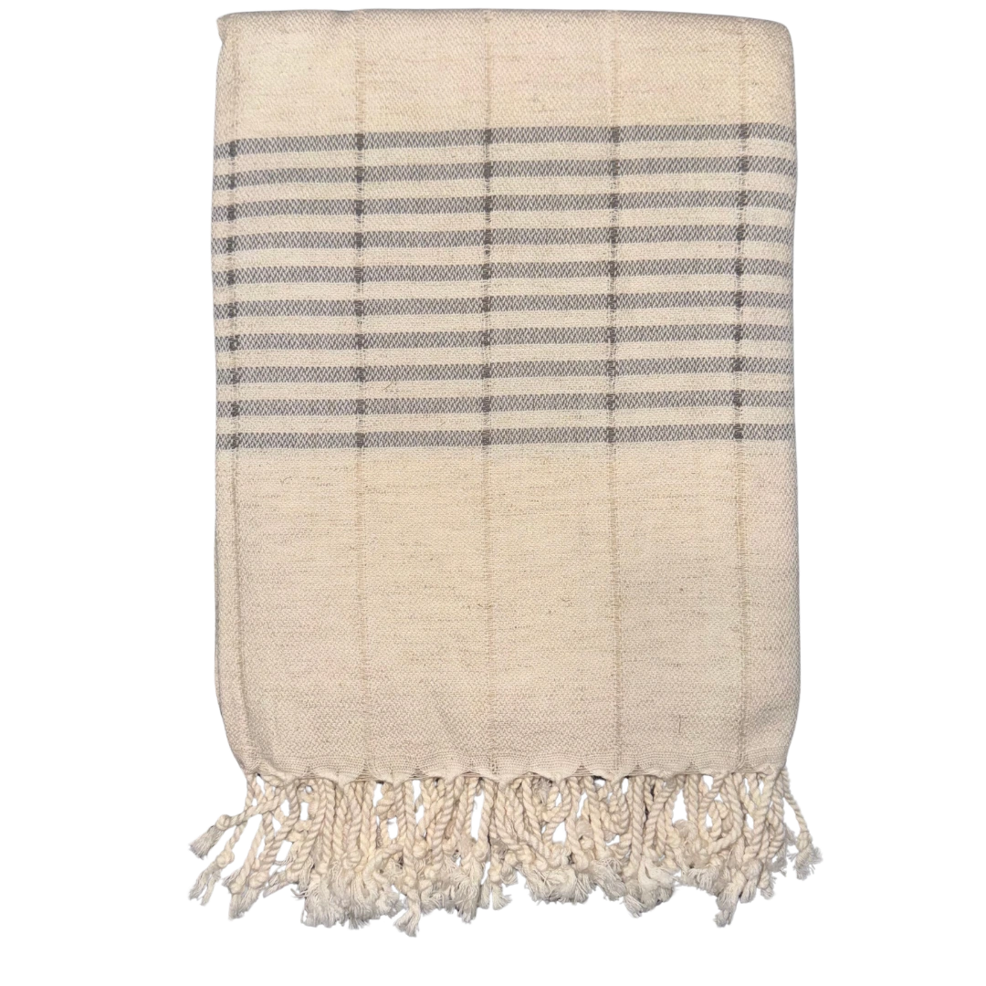 Beige towel with blue stripes and fringes on a white background