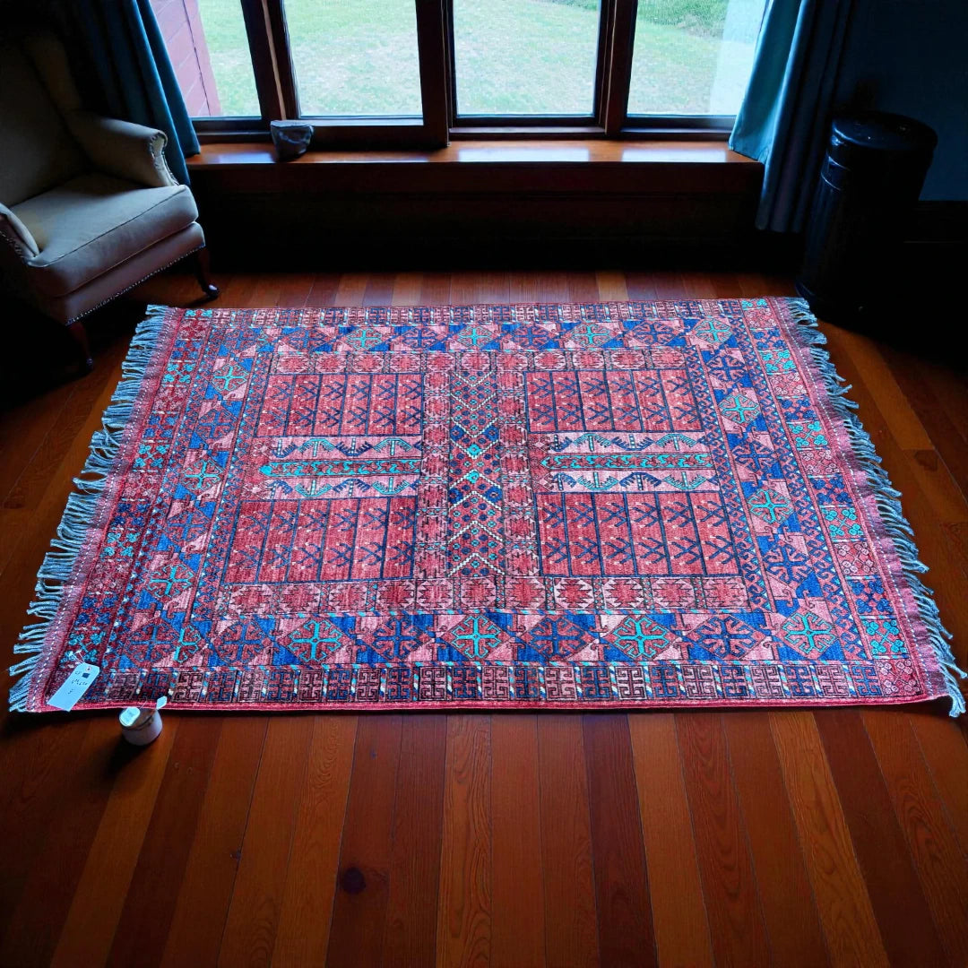 Colorful patterned rug on a wooden floor with a window in the background