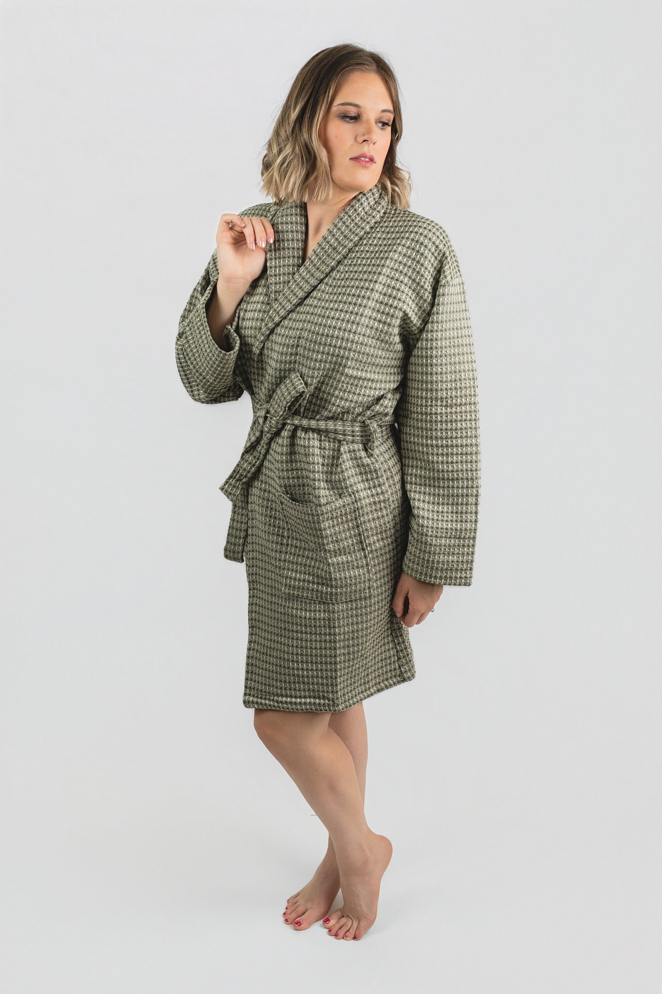 Woman wearing a green checkered robe on a white background