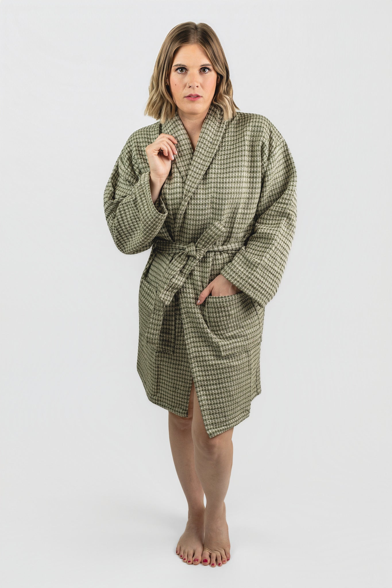 Woman wearing a green checkered robe on a white background