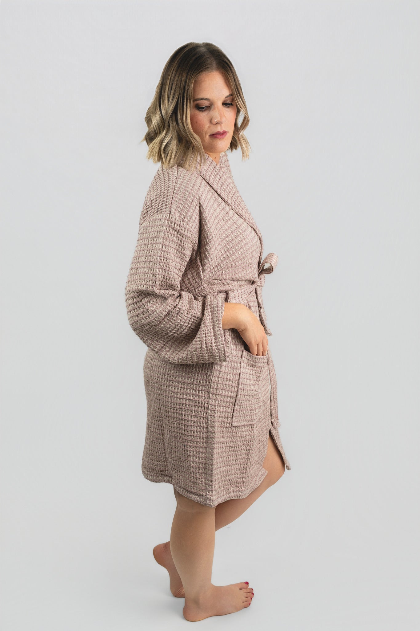 Woman wearing a beige checkered robe on a light gray background