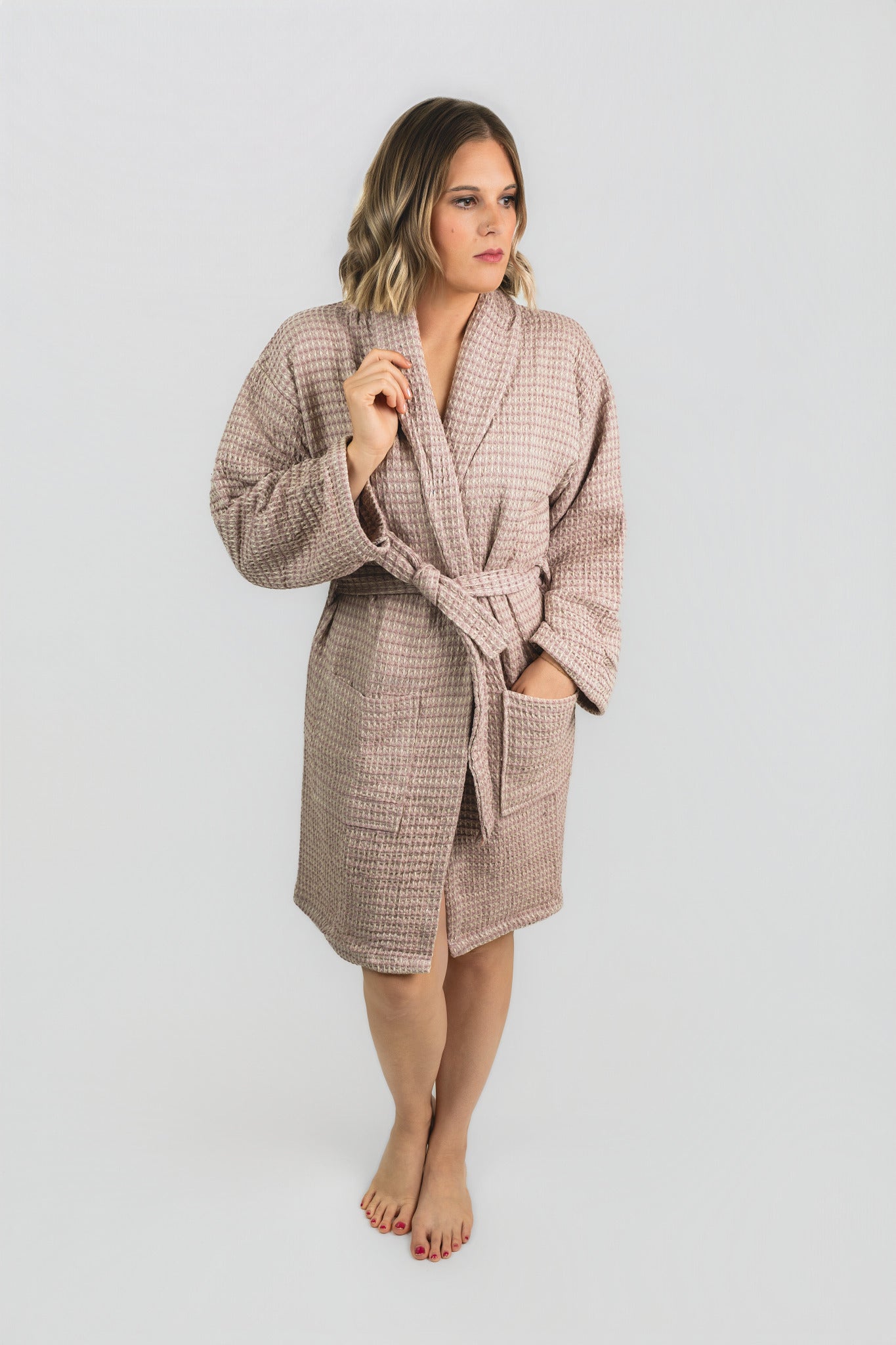 Woman wearing a checkered robe on a plain background