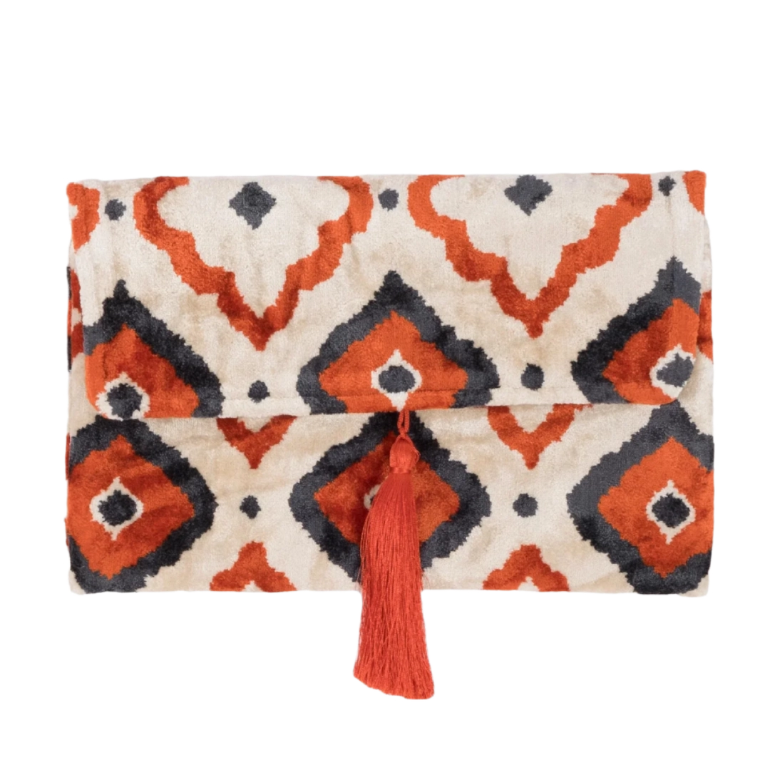 Rust and navy ikat diamond silk velvet clutch with a coral tassel, front view
