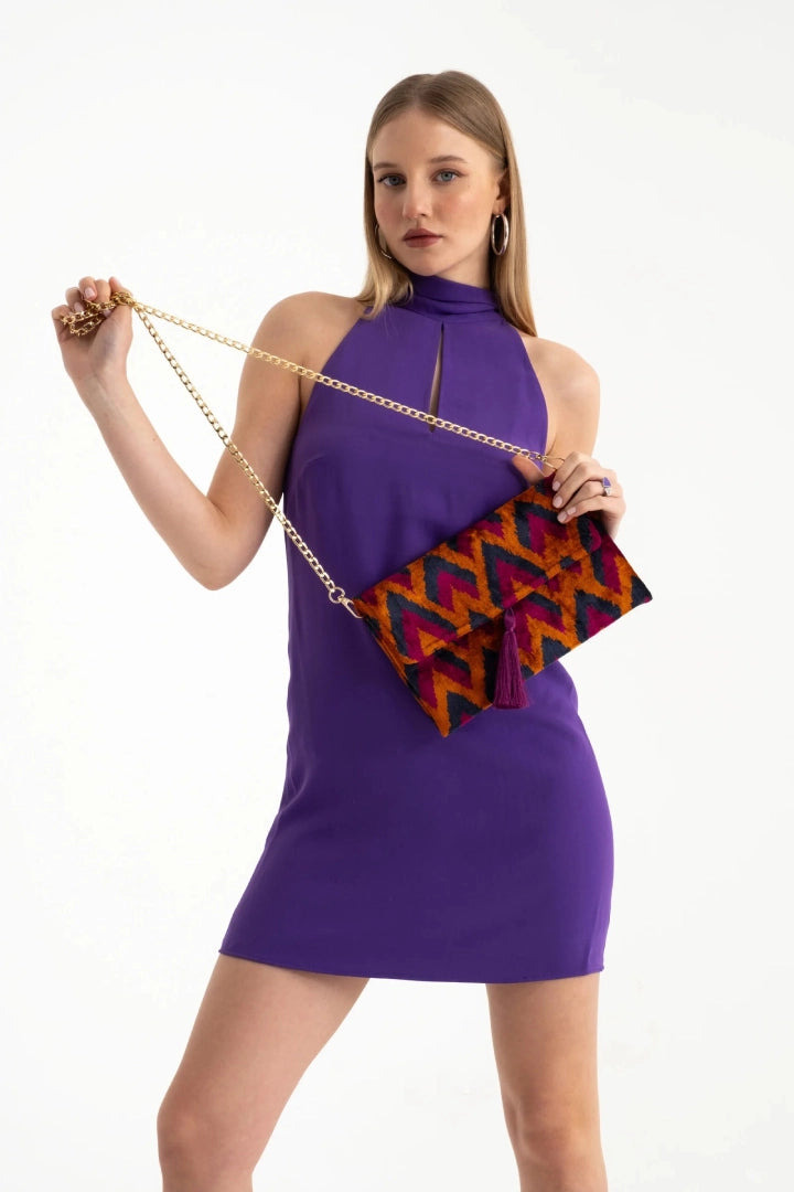 The purple and cinnamon chevron silk velvet clutch carried by its tassel