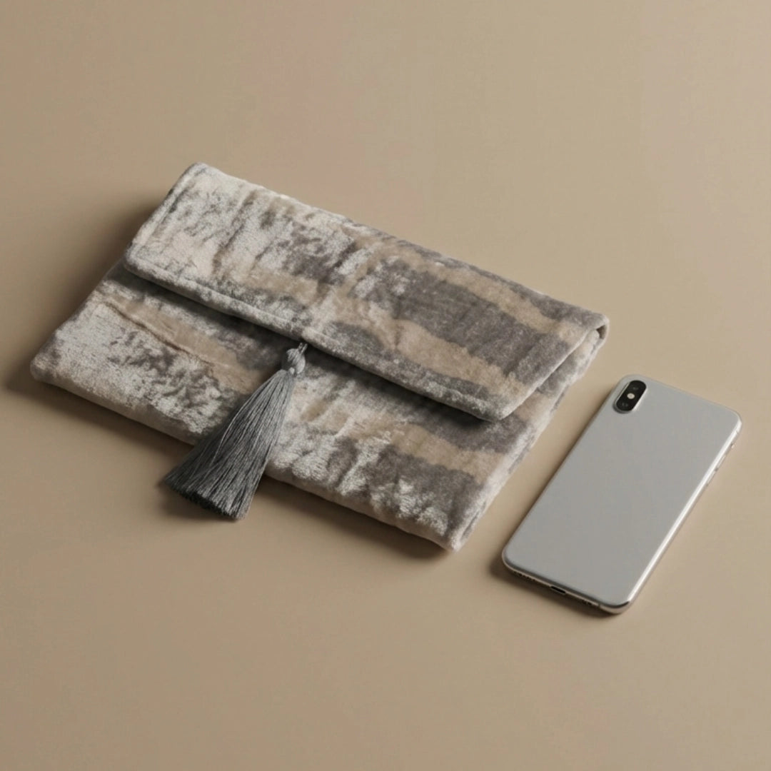 Silver tiger silk velvet clutch shown beside a mobile phone for size reference