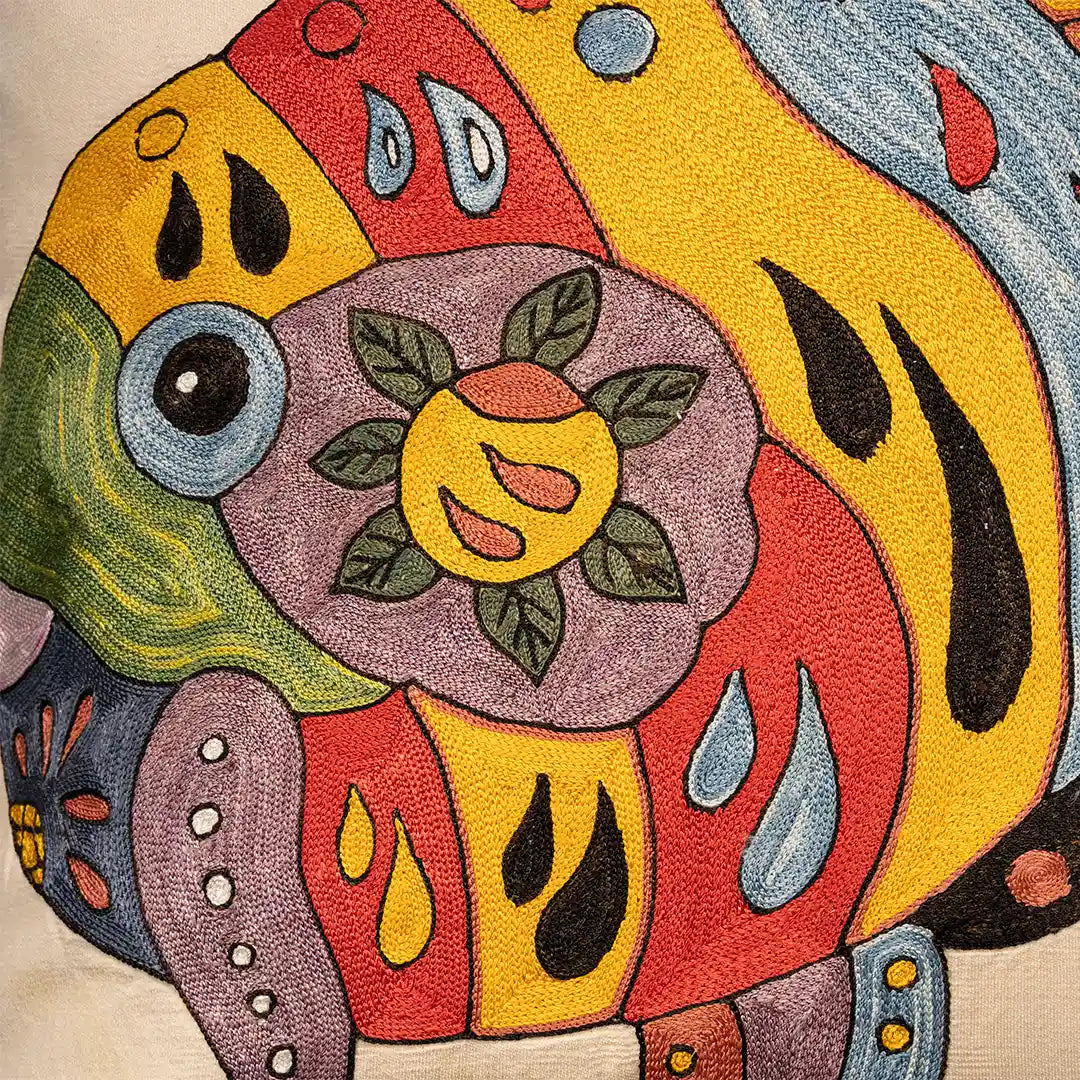 Close-up of the hand-embroidered suzani fish with its floral body and chainstitch outlines