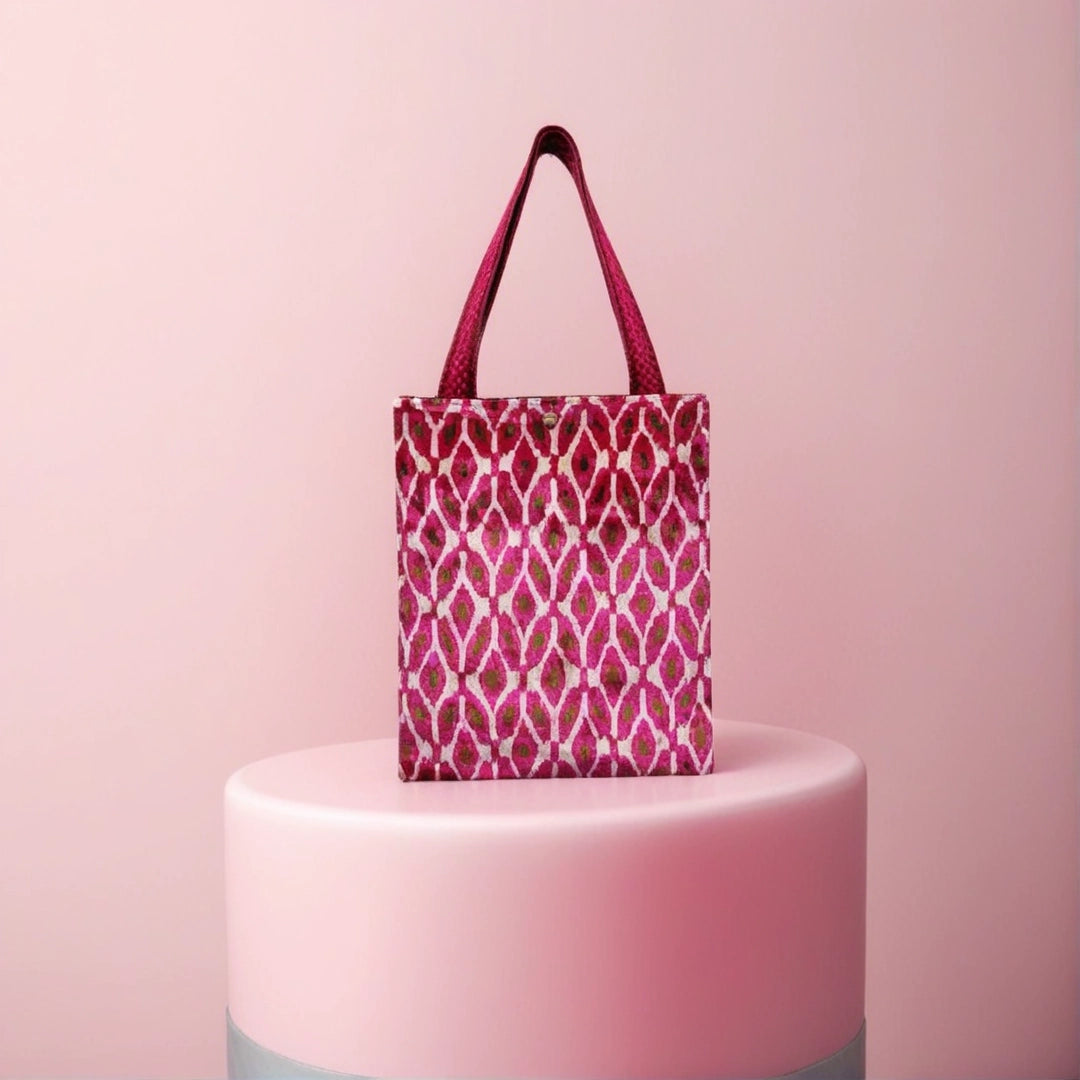 Rose ikat diamond silk velvet shoulder bag styled on a pink pedestal