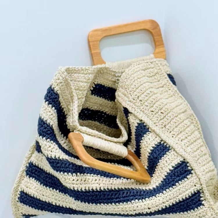 Close-up of the light wooden top handles and striped crochet weave on the Carole tote