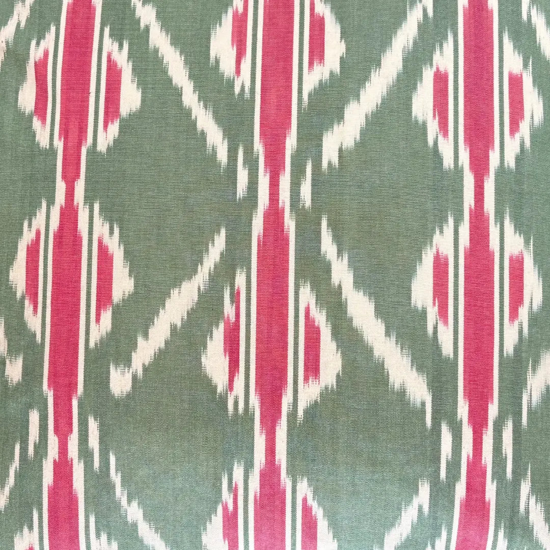 Patterned fabric with pink and white geometric design on a green background