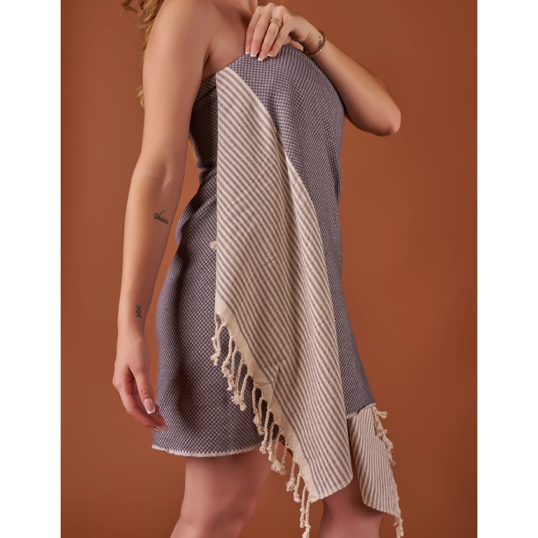 Person holding a striped towel against a brown background