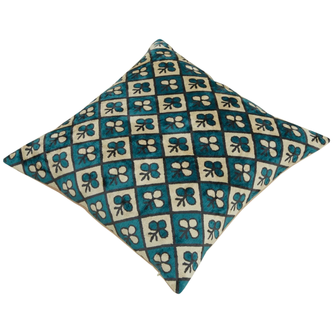 Close-up of silk velvet pillow cover featuring abstract club symbols in soft hues