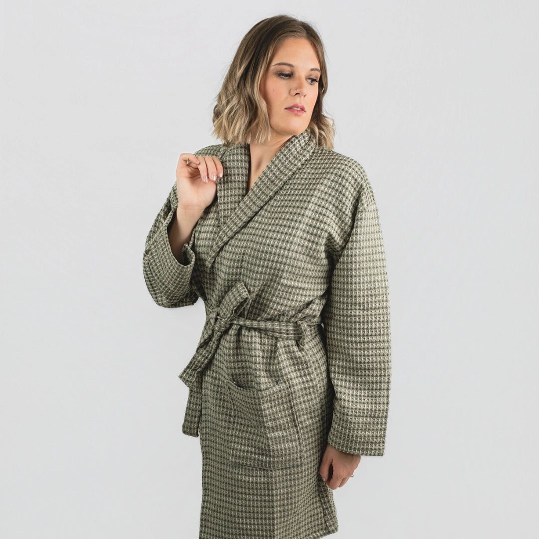 Woman wearing a green checkered robe against a white background