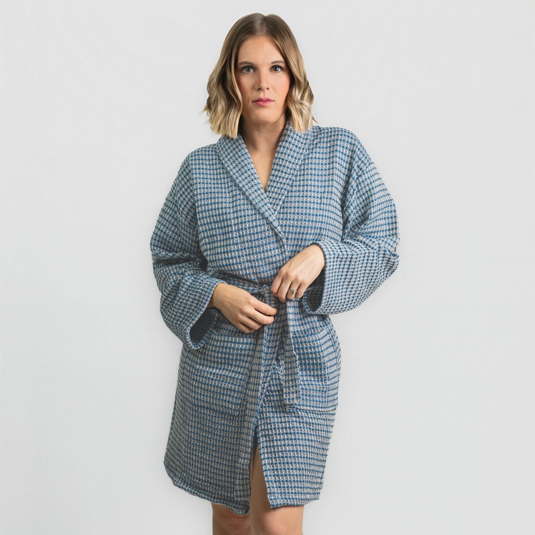 Woman wearing a blue checkered robe against a white background