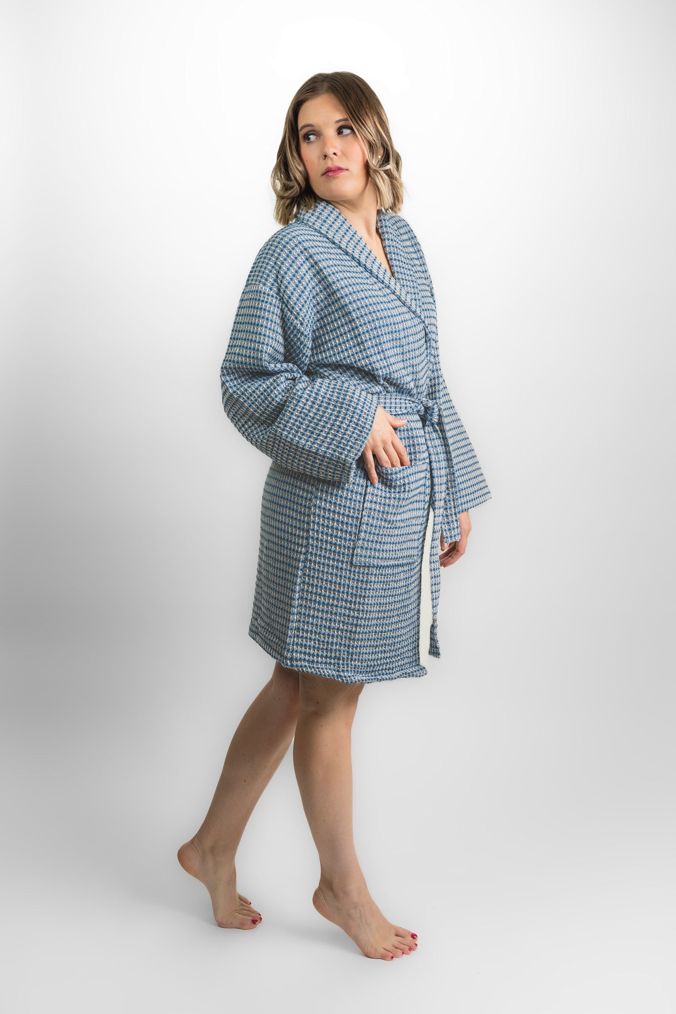 Woman wearing a blue checkered robe on a white background