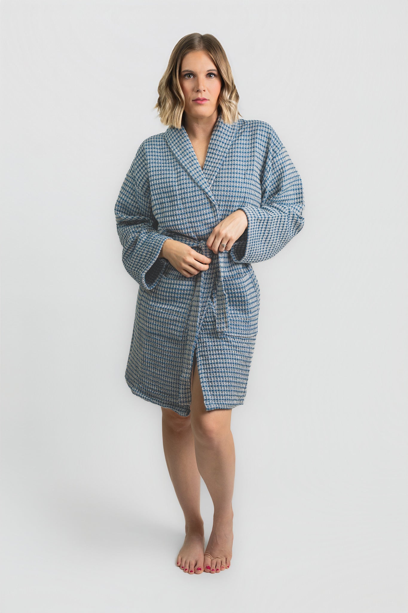 Woman wearing a blue checkered robe on a white background