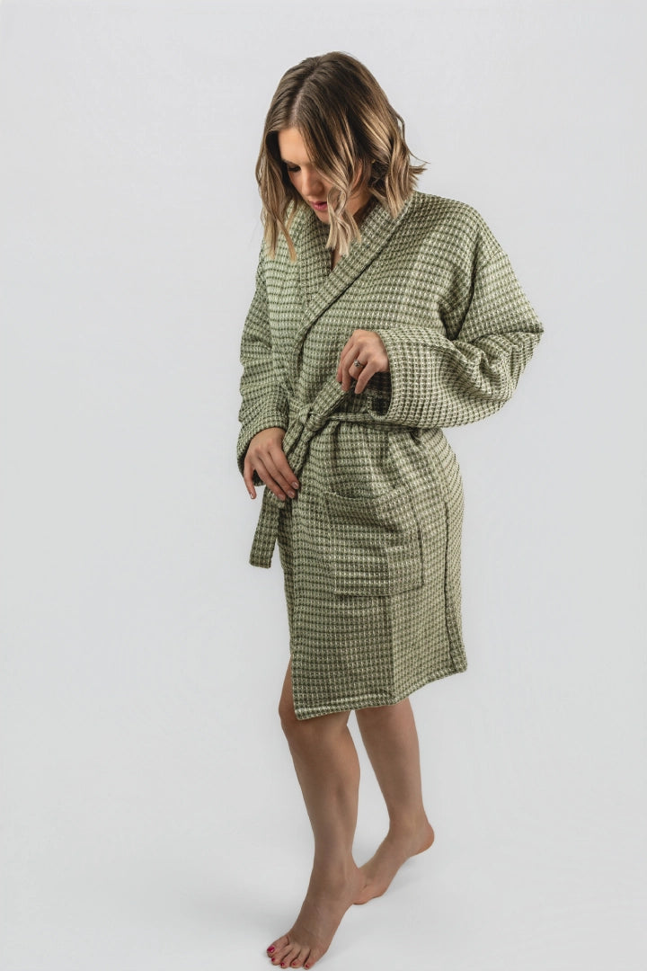 Model tying the belt of the Aegean Olive Green waffle weave peshtemal bathrobe