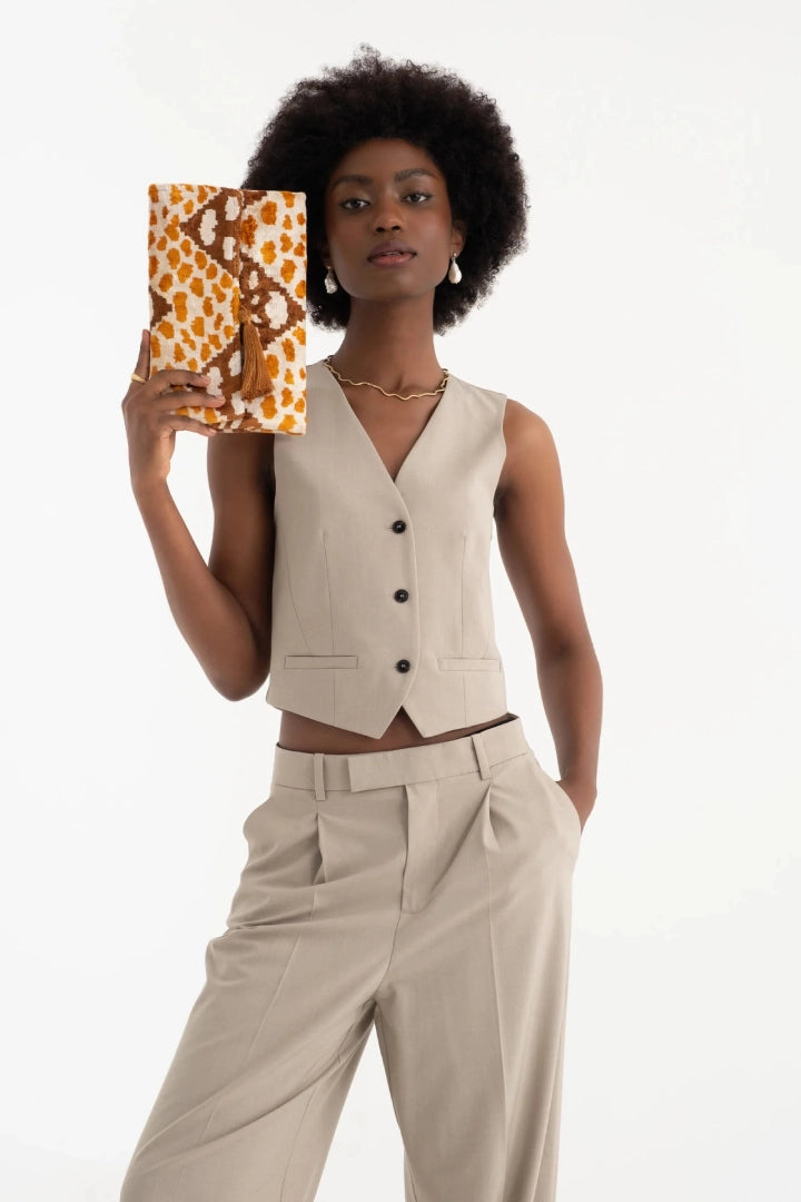 The amber leopard silk velvet clutch held at the hip with a neutral toned outfit