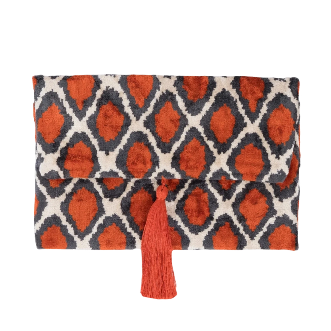 Orange ikat diamonds on an anthracite silk velvet clutch with a coral tassel