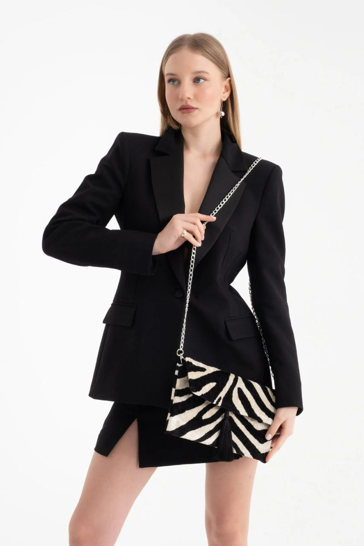 The black and ivory zebra silk velvet clutch carried by its tassel