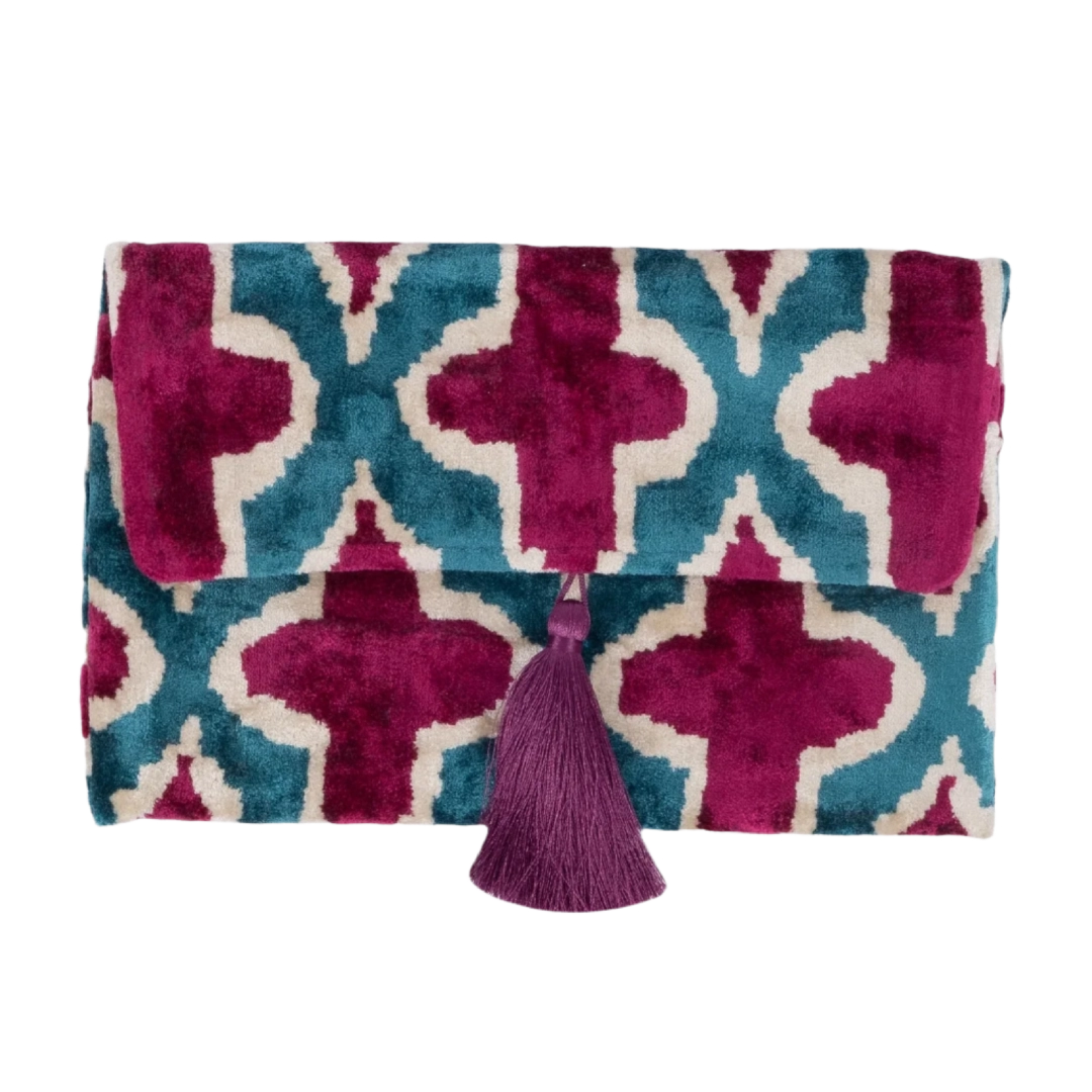 Magenta quatrefoil motifs on a teal silk velvet clutch with a purple tassel