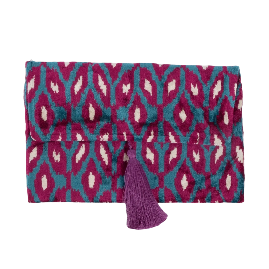 Magenta rana petal motifs on a turquoise silk velvet clutch with a berry tassel