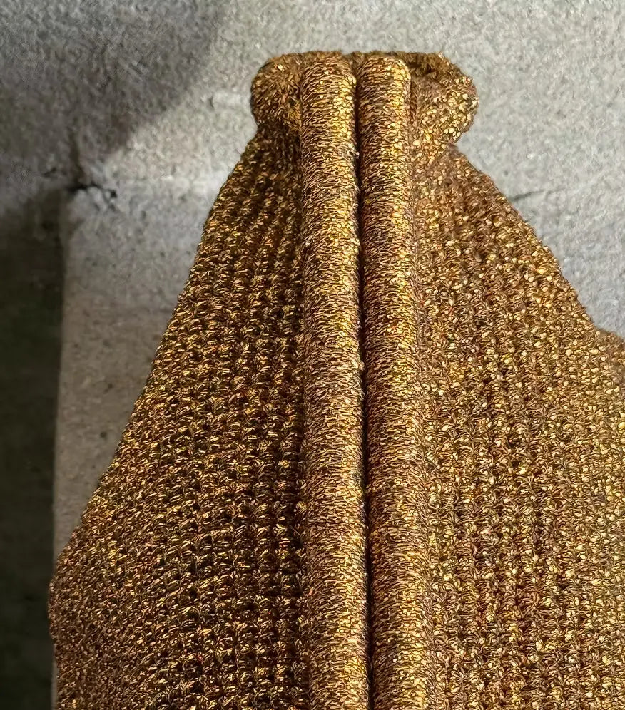 Close-up of the woven metallic texture and pleating on the gold Sabine clutch