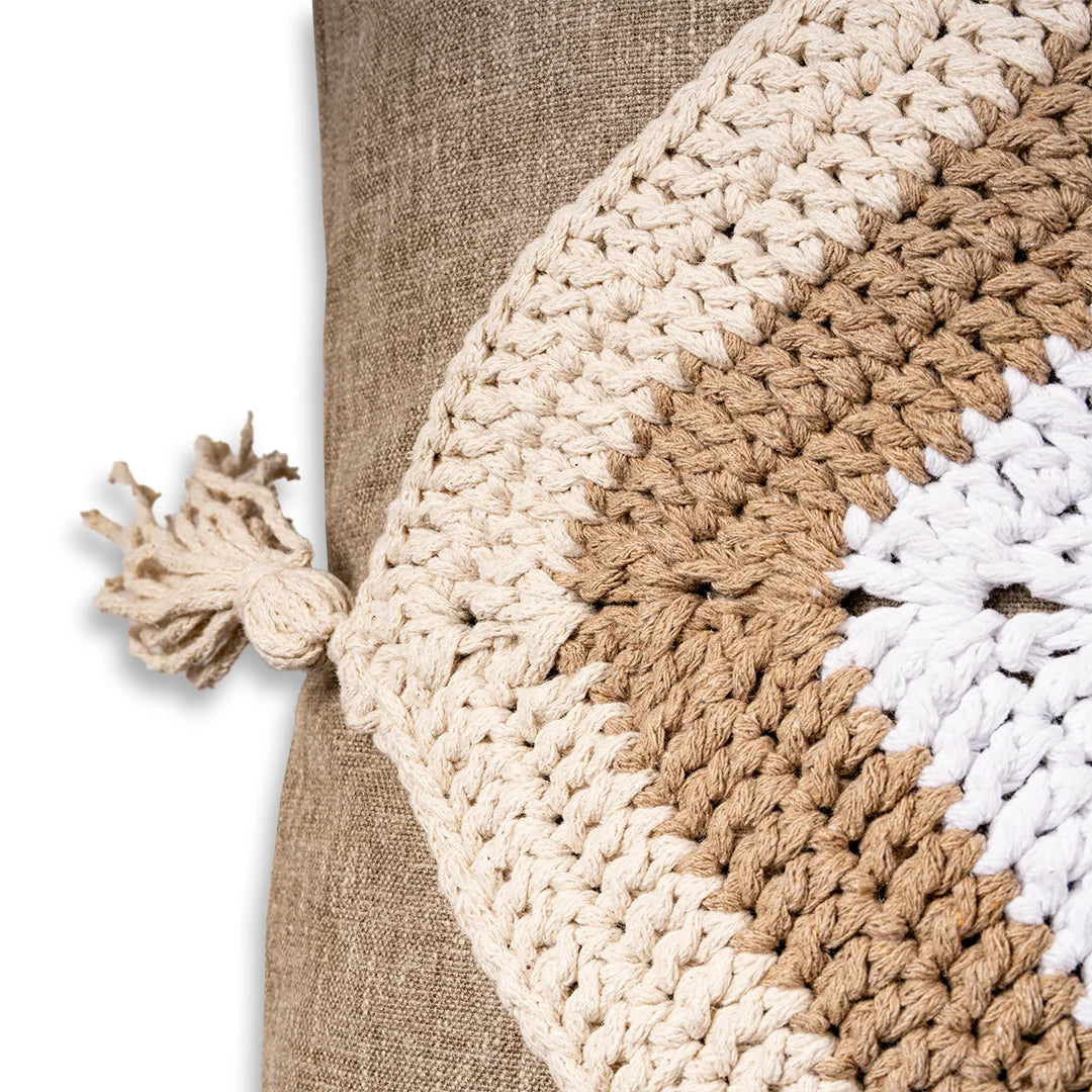 Close-up of the taupe crochet trim and knotted tassel on the linen evil eye cushion