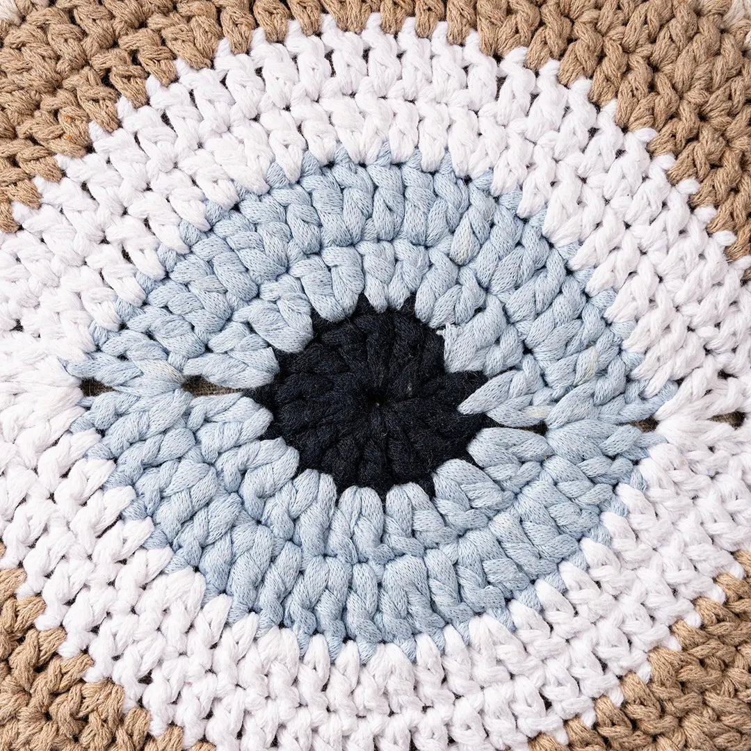 Close-up of the taupe crocheted evil eye motif with its pale blue iris
