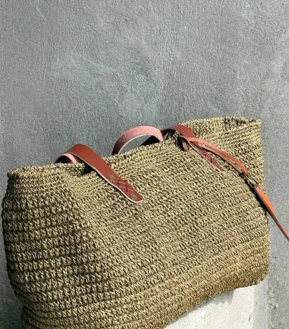 Side view of the Fall Green raffia tote showing its woven texture and slouchy shape