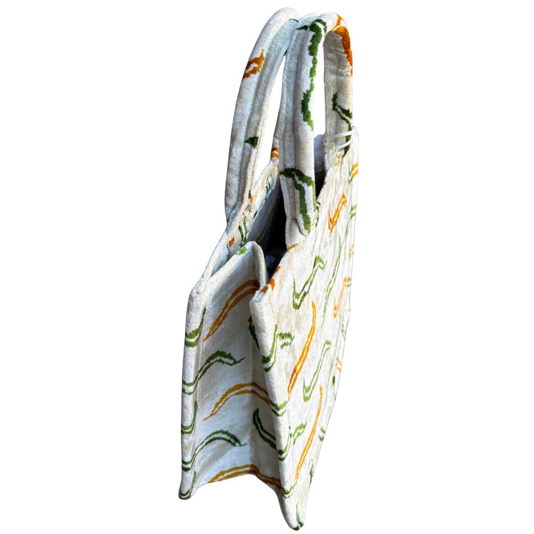 Side view of the Meandering Vine silk velvet tote showing its boxy base and gusset