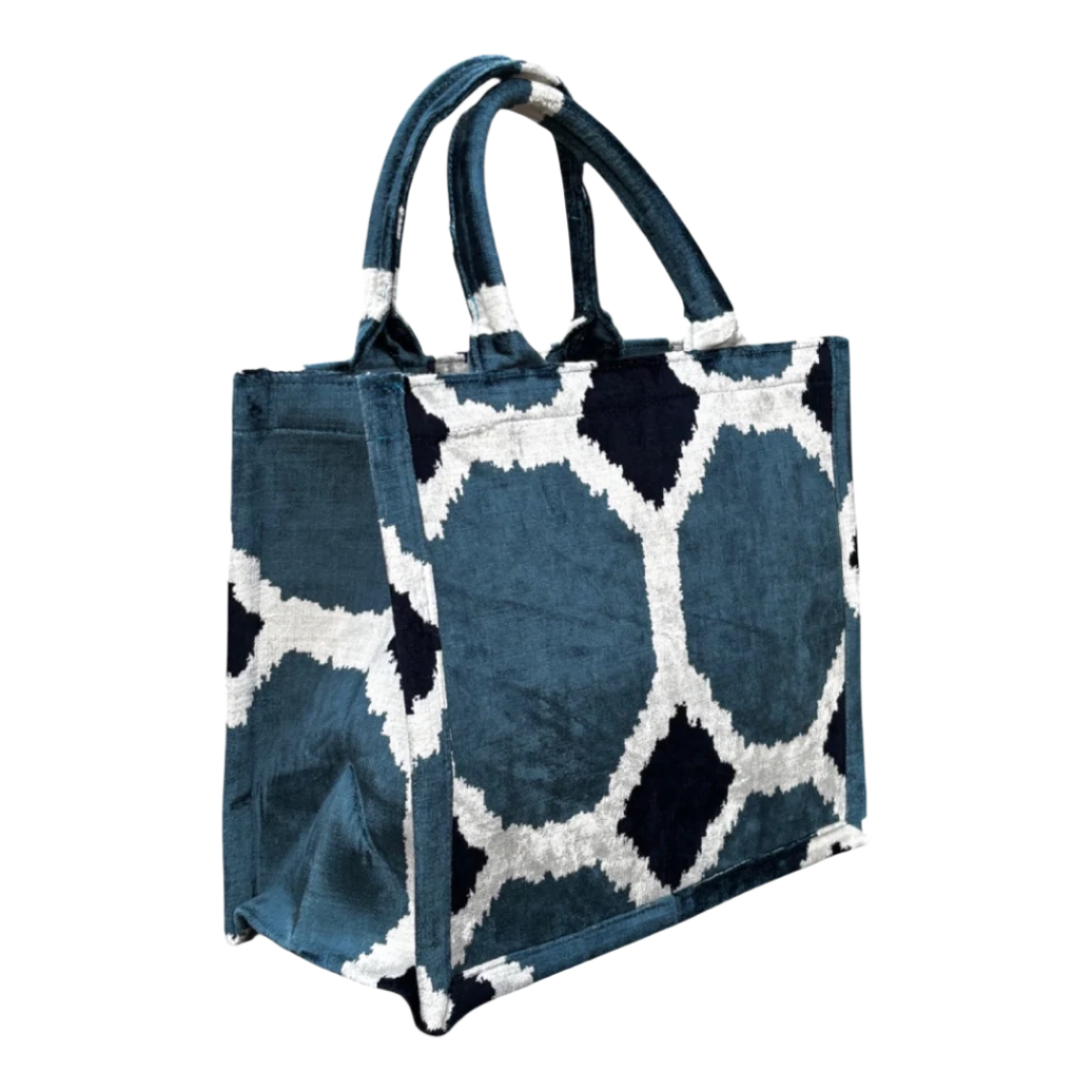 Side view of the Teal Octagon Trellis silk velvet tote showing its boxy base and gusset